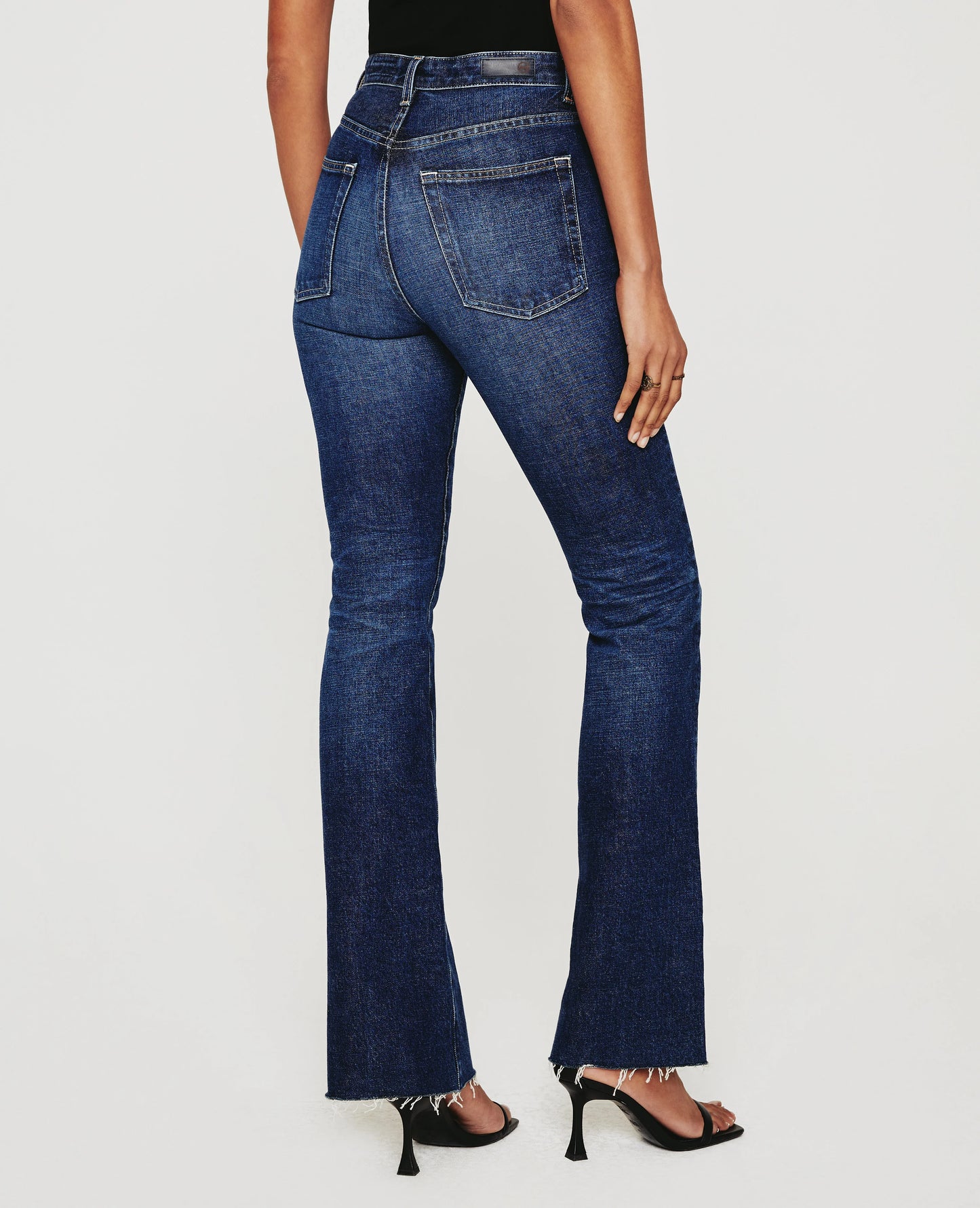 Back Picture of a model wearing the AG Jeans Medium Wash Alexxis Boot - CT Grace