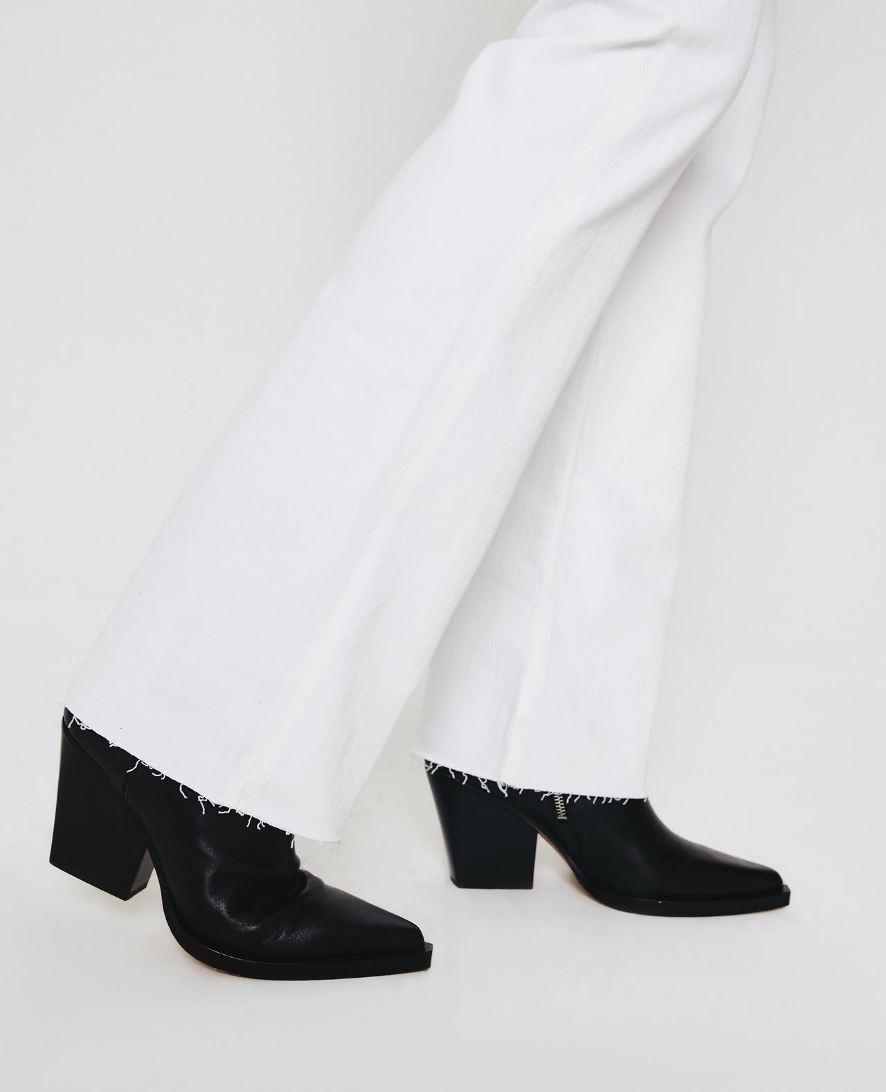 Zoom picture of a model wearing the AG Jeans White Alexxis Boot - CT Grace
