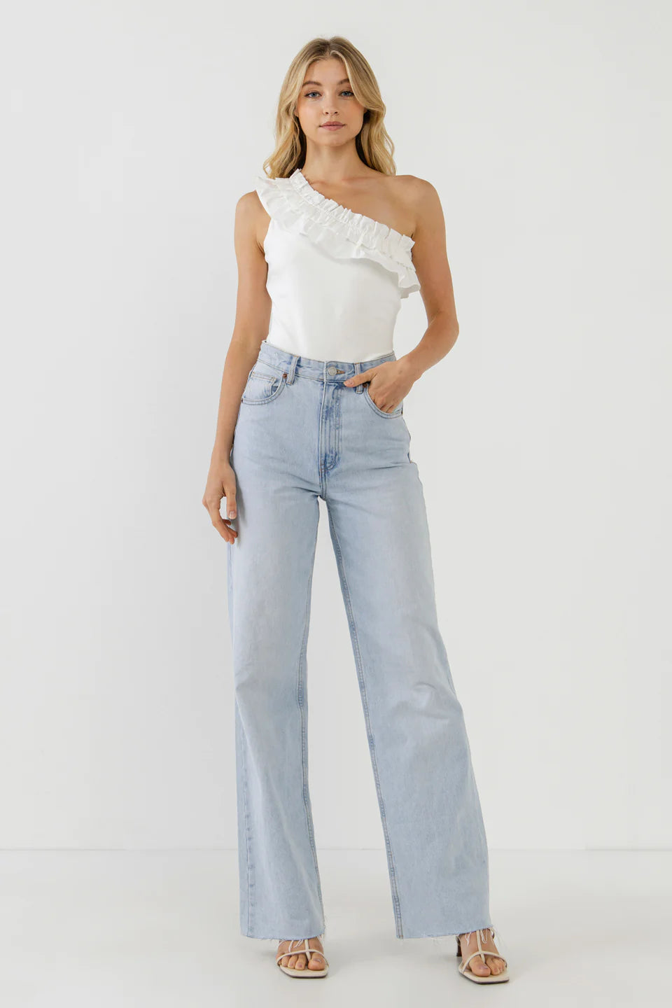 Picture of a blonde model using the Endless Rose White Ruffle Bodysuit and Jeans - CT Grace