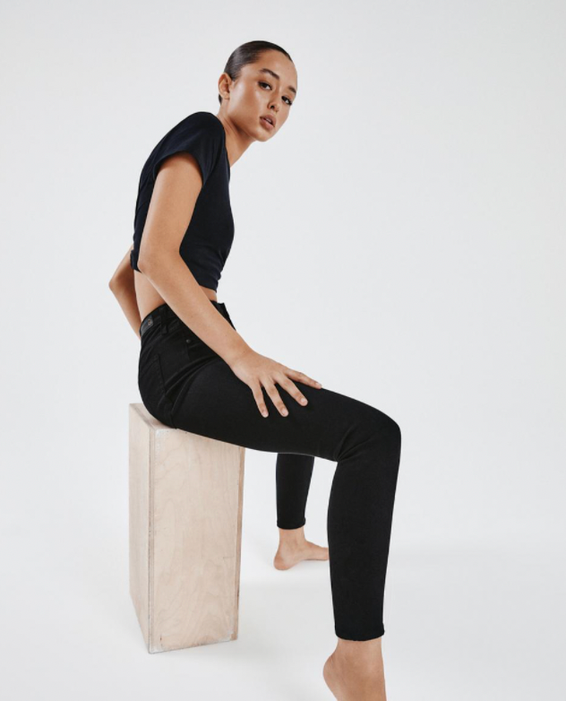 Side picture of a model wearing AG Black Farrah Seamless Ankle Jeans - Super Black - CT Grace