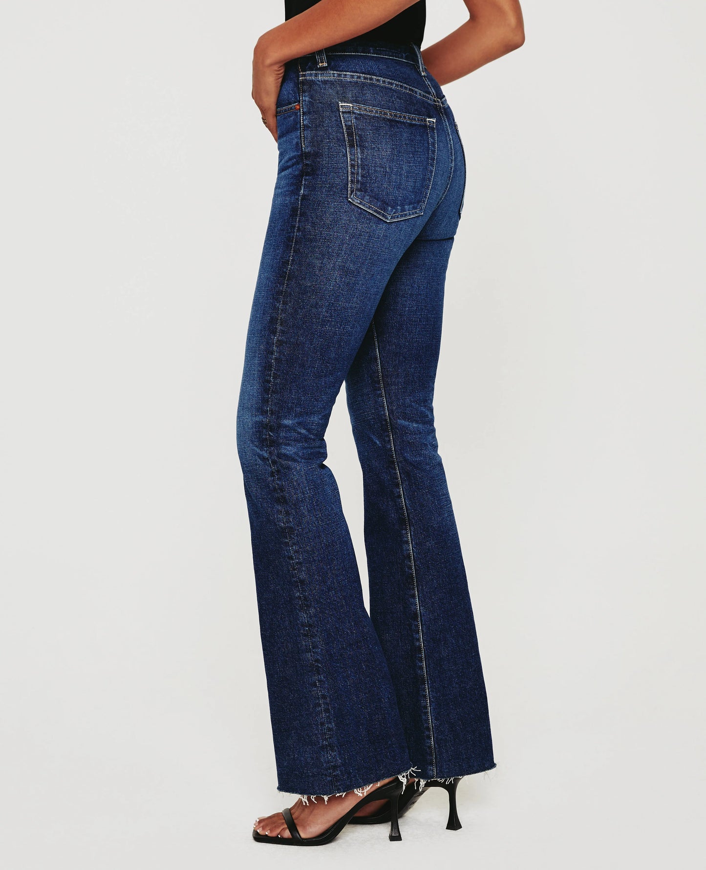 Side Picture of a model wearing the AG Jeans Medium Wash Alexxis Boot - CT Grace