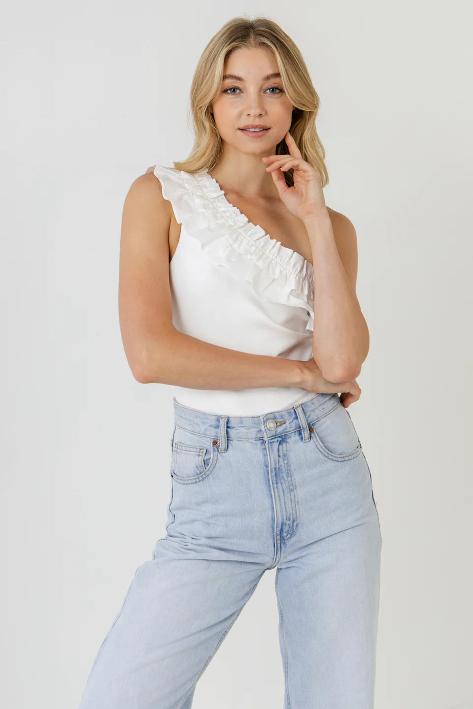 Zoom picture of a blonde model using the Endless Rose White Ruffle Bodysuit and Jeans - CT Grace